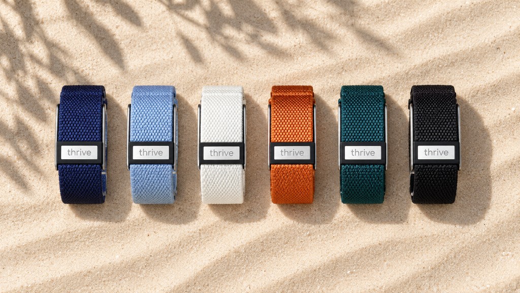 Six Thrive Bands in Deep End, Shallows, Flat White, Outback, Daintree and Wetsuit, laid on sand